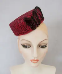 Red felt cocktail hat with hand embroidery.