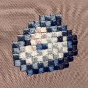 Finished Blue Slime Pixel Art Embroidery design by Erich Campbell seen from an angle