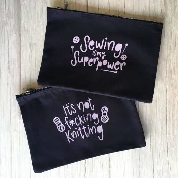 Two project pouches sit on top of a wooden background. One pouch says Sewing Is My Superpower.